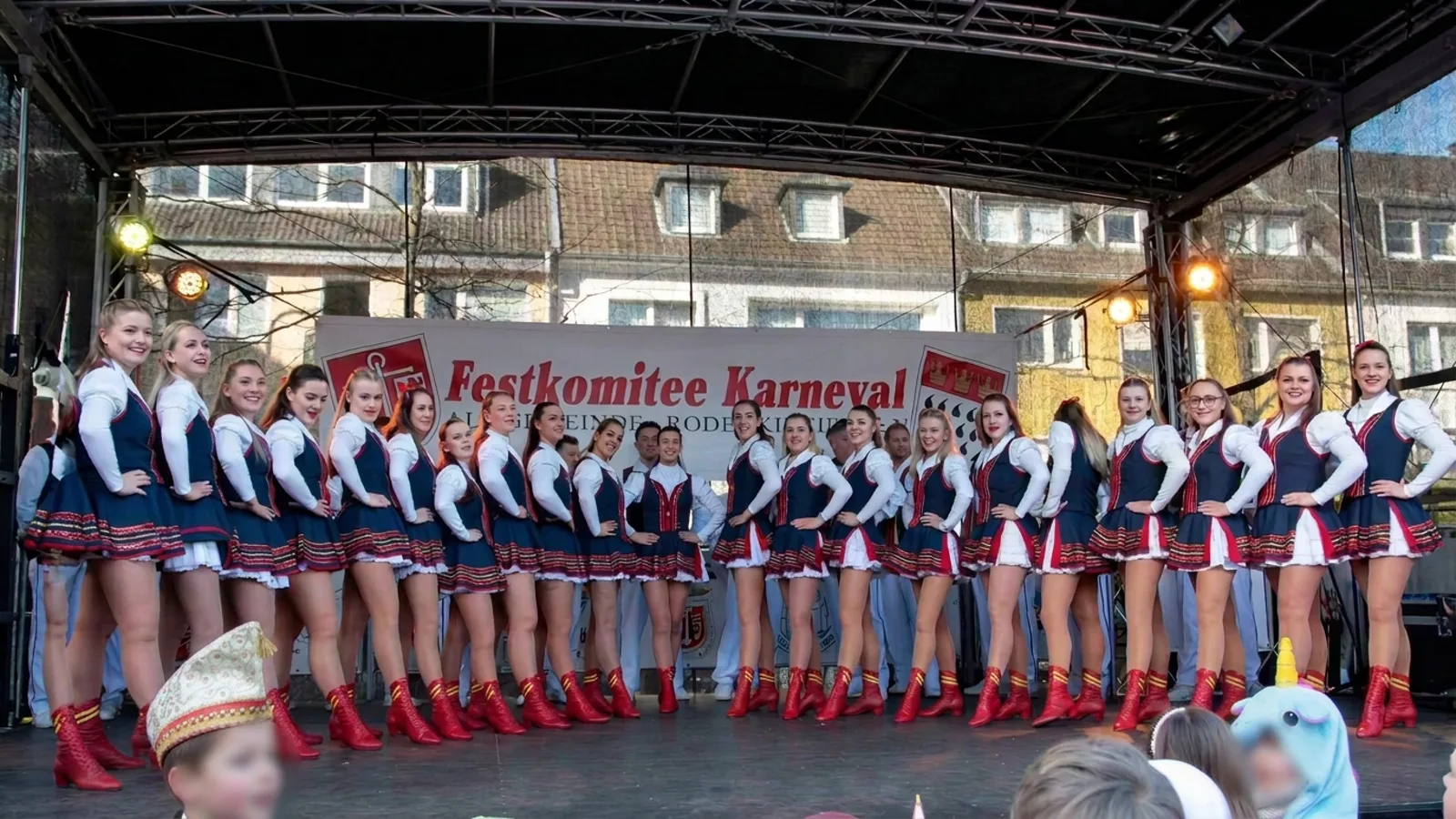 Tanzgruppe vor dem Banner des Festkomitees bei der Straßenkarnevalseröffnung in Rodenkirchen